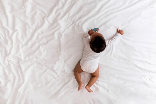 Pequeño Bebé Negro Arrastrándose Cama Jugando Con Juguete Sonajero Vista —  Fotos de Stock