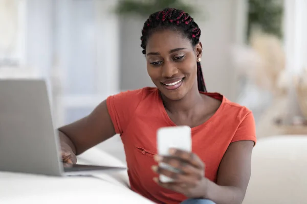 Smiling Black Female Freelancer Mit Smartphone Und Arbeit Mit Laptop — Stockfoto