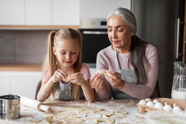 快乐的高加索小孙女和老祖母沾满了面粉 在现代厨房的内部用面团一起做饼干 家庭烹饪课 自制食品和家务活 — 图库照片