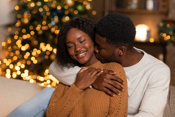Gülümseyen Siyah Koca Karısına Sarılıp Öpüyor Noel Ağacı Parıldayan Çelenklerle — Stok fotoğraf