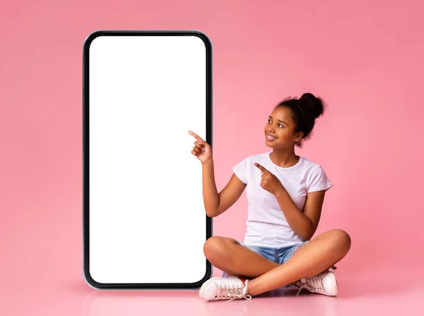 Mobile Offer Smiling Black Teen Girl Pointing Big Blank Smartphone — Stock Photo, Image