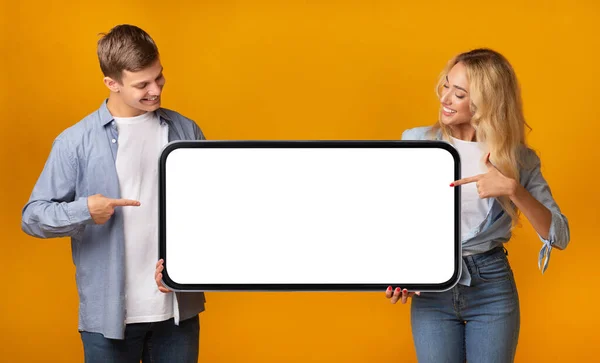 Fröhliches Junges Paar Zeigt Auf Großen Leeren Smartphone Bildschirm Ihren — Stockfoto