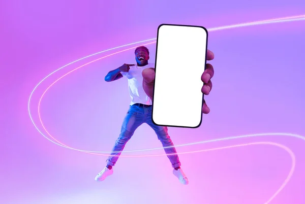 해피잘생긴 아프리카 미국인 평상복 점프와 광고용 스크린을 새로운 스마트폰 라이트 — 스톡 사진