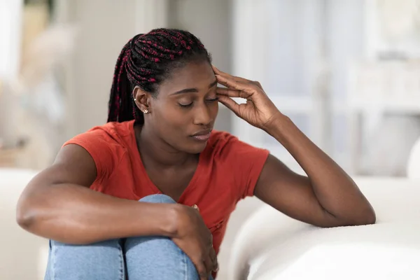 孤独的概念 忧心忡忡的年轻黑人妇女坐在家中的长椅上 孤独压抑的非洲裔美国女性的闭锁画像 痛苦的神经衰弱或抑郁 — 图库照片