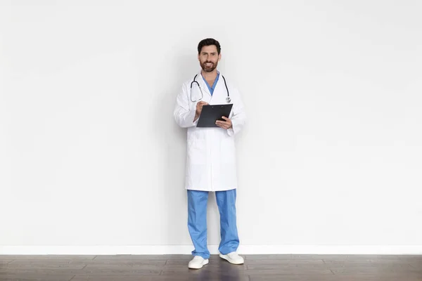 Volledige Lengte Van Glimlachende Dokter Man Medische Jas Met Klembord — Stockfoto