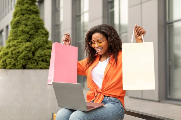 カジュアルで100万人の黒人女性を満足させることは ラップトップに多くの袋を示しており 市内で大きな購入を喜んでいます ビデオ通話 ファッションブログやライフスタイル オファー 広告やオンラインショッピングでの販売 — ストック写真