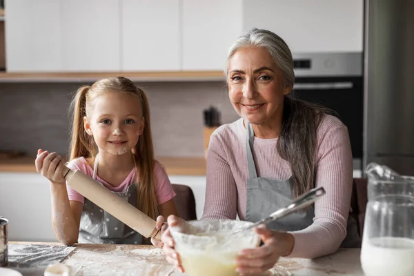 高兴的是 欧洲的小孙女和年迈的奶奶厨师涂上面粉 准备烘焙面团 一起在厨房里玩乐 在家做饭 业余爱好和家务活 — 图库照片