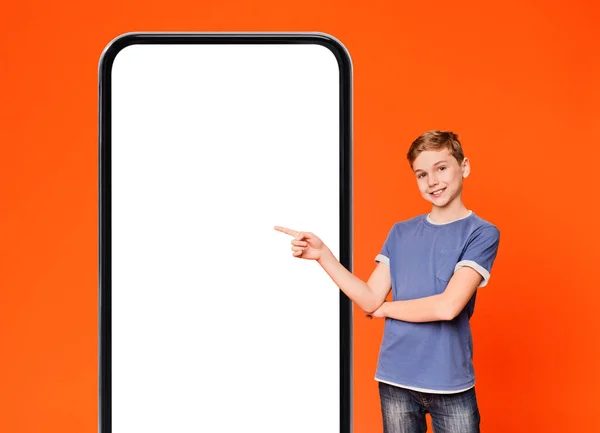 Oferta Online Uśmiechnięty Nastolatek Chłopiec Wskazując Big Blank Smartphone White — Zdjęcie stockowe