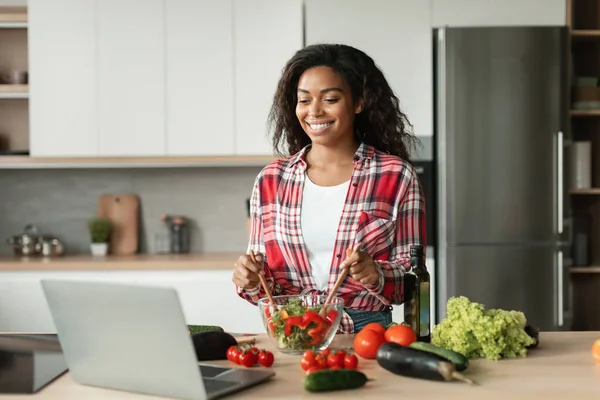 기분좋은 흑인젊은 아가씨는 유기농 야채에서 샐러드를 준비하고 내부에서 레시피에 비디오 — 스톡 사진
