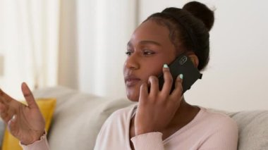 Genç sinirli Afrikalı Amerikalı kadın müşteri müşteri müşteri yardım hattıyla tartışıyor, kötü servis yüzünden yardım almaya çalışıyor, evde oturuyor, çekim takibi yapıyor, yavaş çekim, serbest alan