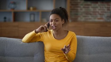 Mesafeli kadın arkadaşlığı. Genç, pozitif, Afro-Amerikan kadının cep telefonuyla konuşan, evde dedikoduları tartışan, yavaş çekim, serbest alan