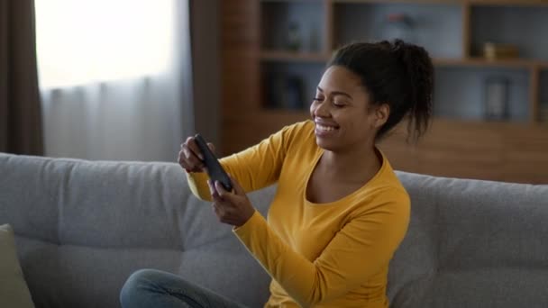 Развлечения Молодая Позитивная Американка Африки Играющая Видеоигры Смартфоне Смеющаяся Развлекающаяся — стоковое видео