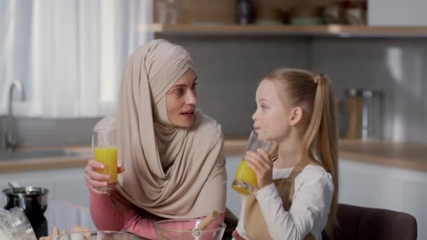 健康的な家庭内習慣 閉じる上のポルノの幸せな愛あるイスラム教徒のお母さんと彼女の小さな娘飲むオレンジジュース一緒にでキッチンと笑い 遅い動き — ストック動画