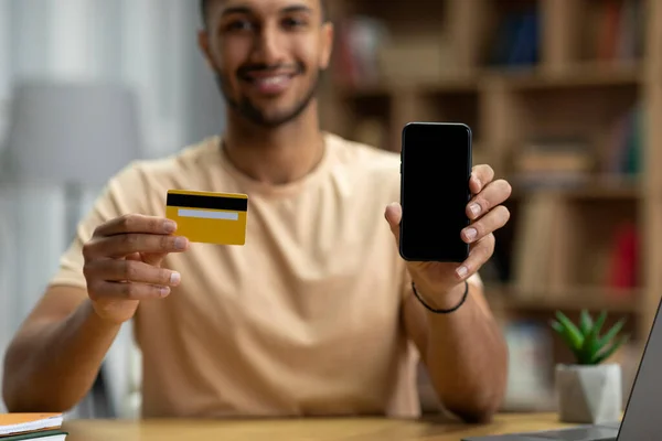 Szczęśliwy Młody Arabski Człowiek Pokazuje Smartfon Czystym Ekranem Kartą Kredytową — Zdjęcie stockowe