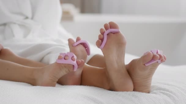 国内放松 大脚和小脚在床上的特写镜头 难以辨认的母女一起享受着修脚 慢动作 自由自在的空间 — 图库视频影像