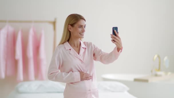 在线交流 穿着睡衣的积极孕妇与家人或朋友聊天 早上站在家里 慢动作 自由自在 — 图库视频影像