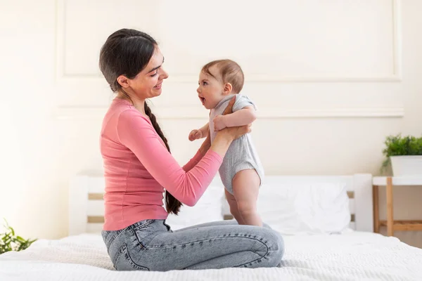 Young Loving Mom Holding Baby Girl While Sitting Bed Bedroom — Stock Photo, Image