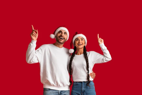 Dreamy Arab Couple Wearing Santa Hats Pointing Copy Space Theit — Stock Photo, Image