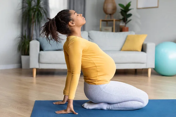 快乐漂亮的年轻黑人孕妇 大肚皮做运动 在客厅里练瑜伽 伸展训练 身体和保健 独自在家运动和怀孕 — 图库照片