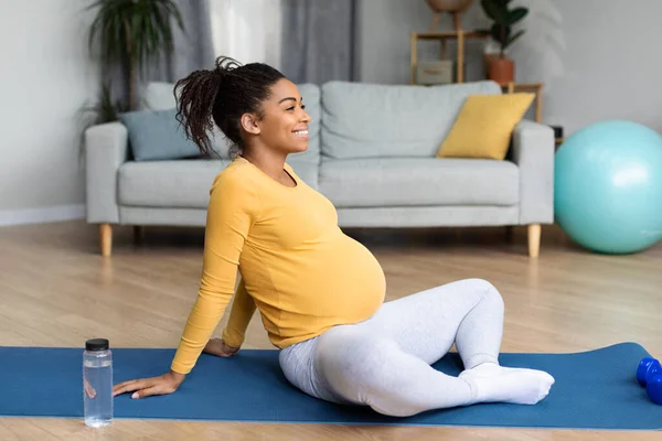 大きな腹を持つ幸せな若い黒人妊婦は リビングルームのインテリアでスポーツワークアウト後にヨガ 休息とリラックスを練習しています 一人で家での体と健康管理と子供の期待 — ストック写真