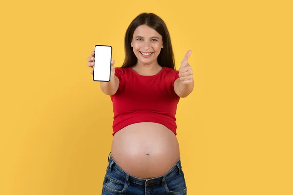 Super App Usmívající Těhotná Žena Ukazuje Prázdný Smartphone Gestikulace Palec — Stock fotografie