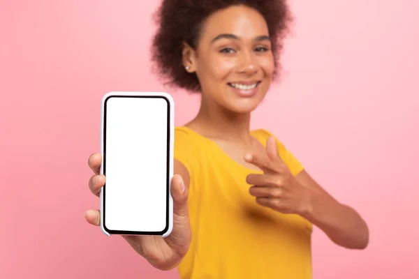 笑千年非洲裔美国卷曲女人手指在手机上用空屏幕 孤立在粉红的背景下 工作室 博客推荐 新应用 伟大的在线广告和提供 — 图库照片
