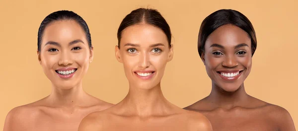 三位迷人的多文化半裸体年轻女士在米色工作室的背景上对着相机微笑 展示她们美丽的笑容和完美光滑的皮肤 健康概念 — 图库照片