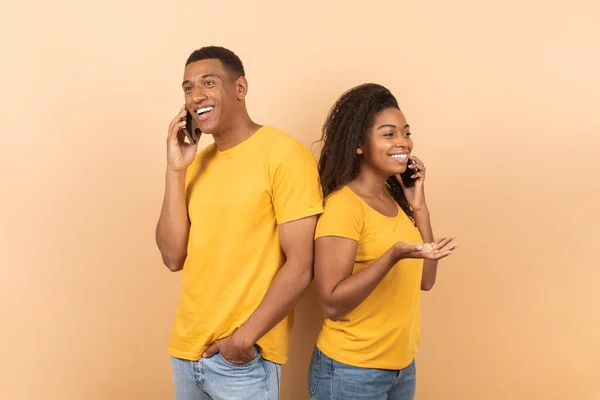 Pozitif Siyah Çift Sırt Sırta Dururlar Cep Telefonlarıyla Şeftali Rengi — Stok fotoğraf