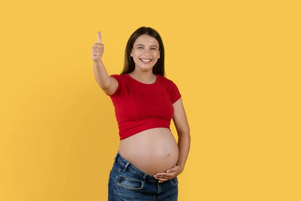 Smiling Young Pregnant Woman Touching Belly Gesturing Thumb Camera Happy — Stok Foto