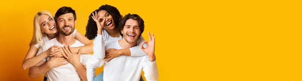 黄色のスタジオの背景に2つの美しい幸せなカップルを受け入れ 笑顔とジェスチャー 楽しい 一緒に時間を楽しむ コピースペースとパノラマを持つ陽気な多人種の千年の愛好家 — ストック写真