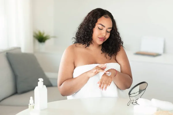 Zwarte Oversized Vrouw Aanbrengen Hydraterende Crème Lotion Haar Handen Zitten — Stockfoto
