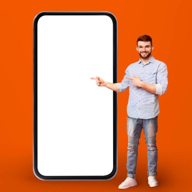 Çevrimiçi teklif. Yakışıklı Genç Adam Büyük Boş Akıllı Telefon 'u işaret ediyor, Gülümseyen Milenyum Adamı Beyaz Ekran ile Büyük Telefon Gösteriyor, Cep Telefonu Uygulaması veya Web Sitesi Öneriyor, Kolaj,