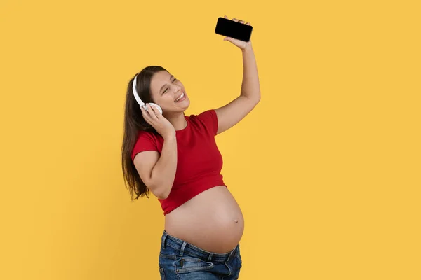 Alegre Mujer Embarazada Escuchando Música Con Smartphone Auriculares Inalámbricos Feliz —  Fotos de Stock