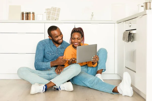 Ευτυχισμένοι Μαύροι Σύζυγοι Που Χρησιμοποιούν Φορητό Υπολογιστή Και Αναζητούν Συνταγές — Φωτογραφία Αρχείου