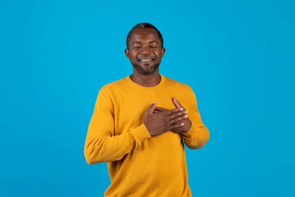 Spokojny Afrykański Mężczyzna Średnim Wieku Żółtym Trzymający Się Ręce Nad — Zdjęcie stockowe