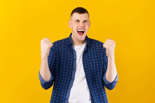 感情的な若い白人男性が叫び 黄色のスタジオの背景に拳を振る 勝利のお祝い 喜びの感情の概念 — ストック写真