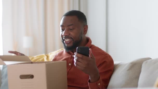 Jovem Afro Americano Positivo Desempacotar Caixa Entrega Casa Comparando Compra — Vídeo de Stock