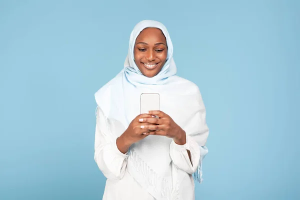 Mujer Musulmana Afroamericana Alegre Sosteniendo Teléfono Inteligente Moderno Mirando Pantalla —  Fotos de Stock