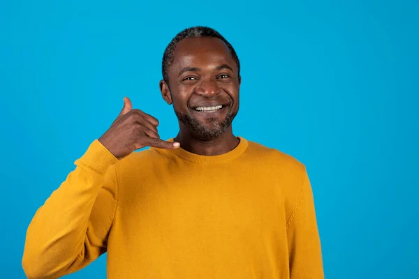 電話してくれ 青い背景に隔離されながら私のサインと笑顔を示す黄色のハンサムな中年アフリカ系アメリカ人男性 スタジオショット 広告のためのコピースペース — ストック写真