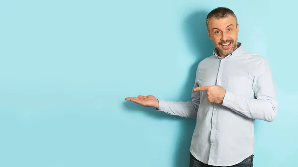 Excited Caucasian Mature Man Pointing Finger Open Palm Posing Blue — Stock Photo, Image