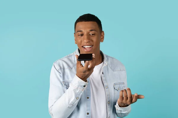 用智能手机随意打电话给千禧年的非洲裔美国人 与朋友聊天 与蓝色背景隔离 远程见面 聊天应用为社交距离 好消息为Covid 19隔离 — 图库照片