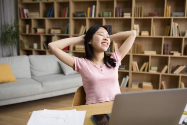 Mutlu Koreli bayan elleri dizüstü bilgisayarın yanında oturuyor işten sonra ya da evde internetten ders alıyor. Uzaktan eğitim ya da uzak iş kavramı