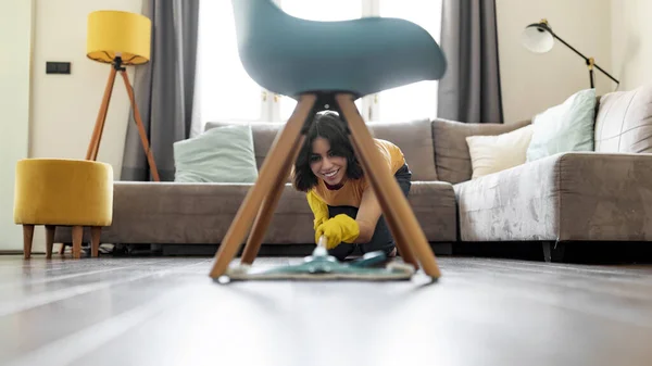 Usmívající Mladá Arabská Žena Drhnutí Podlahy Pod Židlí Doma Veselý — Stock fotografie