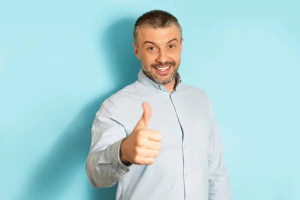 Happy Mature Man Gesturing Thumb Hand Smiling Camera Standing Blue — Stock Photo, Image