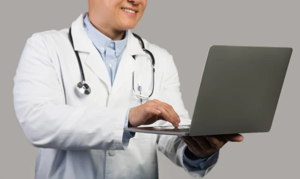 Ευτυχισμένος Ώριμος Κινέζος Θεραπευτής Λευκό Παλτό Στηθοσκόπιο Δακτυλογράφηση Στον Υπολογιστή — Φωτογραφία Αρχείου