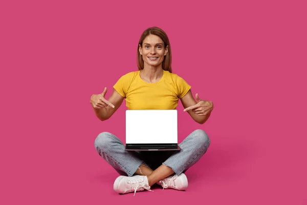 Sıradan Giyinmiş Mutlu Beyaz Kadın Yere Oturur Dizüstü Bilgisayarı Işaret — Stok fotoğraf