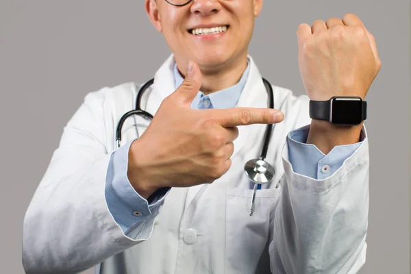 Beyaz Önlüklü Mutlu Asyalı Doktor Boş Ekranlı Saati Işaret Ediyor — Stok fotoğraf