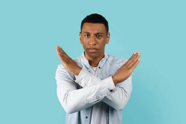 严肃而英俊的年轻非洲裔美国男人 身穿休闲装 交叉双臂做停车标志 隔离在蓝色背景下 工作室 反对种族主义 暴力和Covid 19检疫 面部表达的手势 — 图库照片