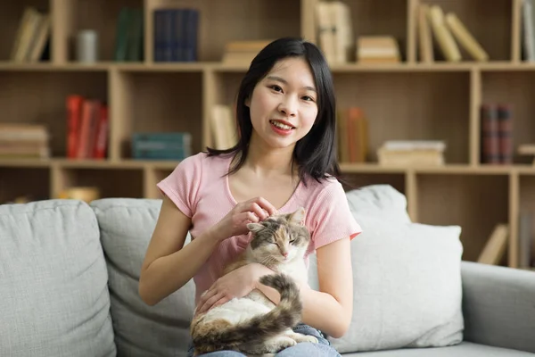 幸せなアジアの女性の肖像画自宅のリビングルームで彼女のペットと過ごす時間を楽しんで ソファに座って カメラで笑顔 猫を保持し それをペット 結合概念 — ストック写真
