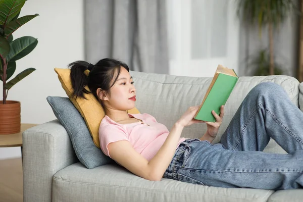 Señora Coreana Despreocupada Acostada Sofá Sala Estar Lectura Libro Mientras — Foto de Stock